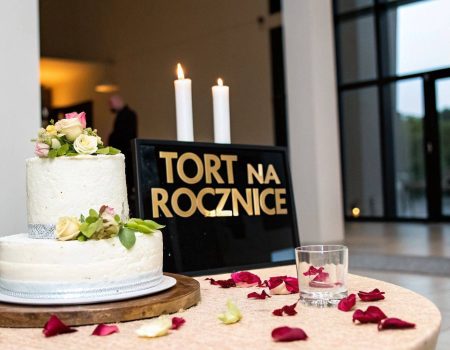 Grafika z napisem Tort na rocznicę i świecami na stole